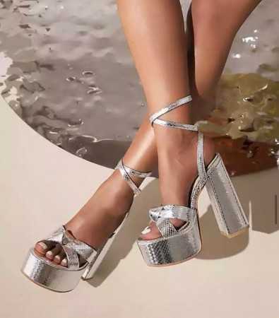 Magnifique chaussures argent à platforms avec talon épais et lanières à la cheville.